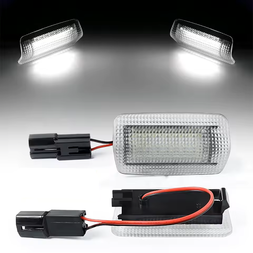 White full replacement LED courtesy lights with wiring harnesses on a gray background