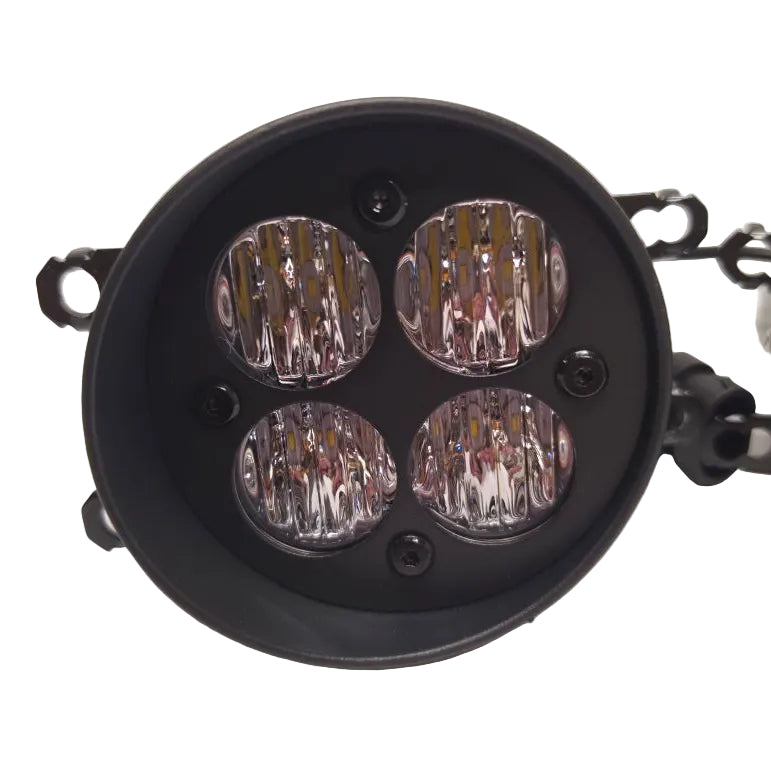 A round black LED light fixture with four clear prismatic lenses arranged in a square pattern, shown on a light gray background.